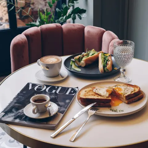 Marble table with cappuccino, espresso and brunch, dusty-pink velvet chairs